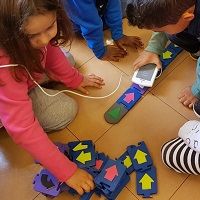 Colored wooden blocks equipped with RFID tags that fit together to form a program running in the Scratch environment.