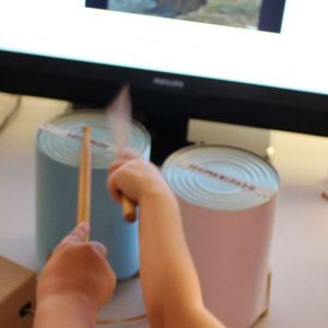 Niños tocando los tambores y viendo la animación en la pantalla.